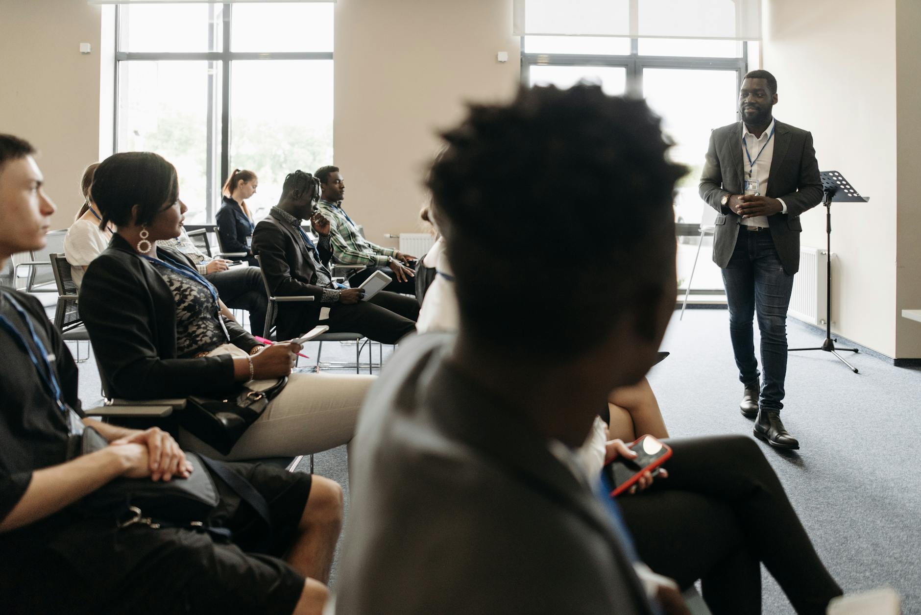 people sitting on the chair listening to the man speaking inside the conference room